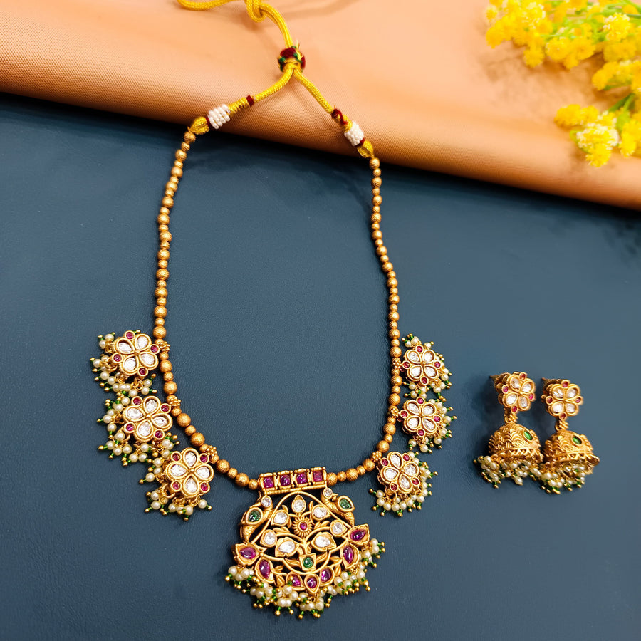 Gold-tone choker with antique charm, featuring Indian motifs for a timeless bridal look.