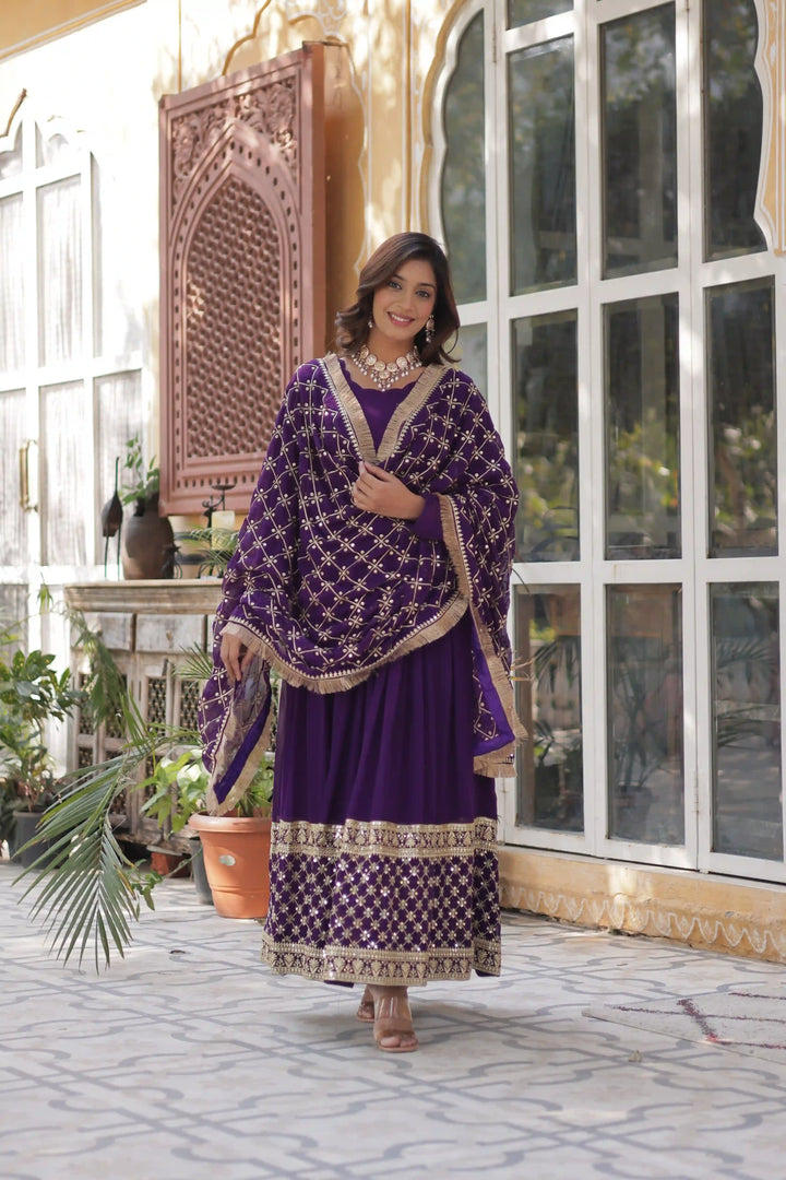 Front view a woman in a purple and gold embroidered dress.