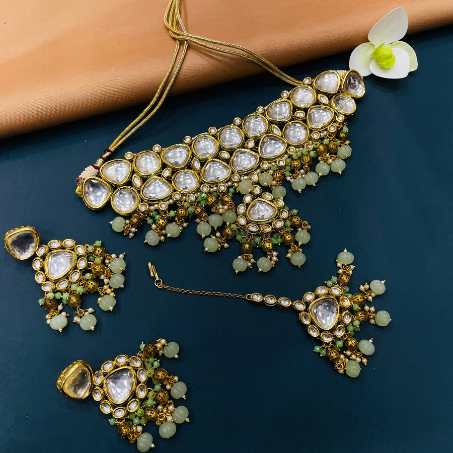 Elegant gold-tone Kundan jewelry with Indian patterns, ideal for cultural attire.