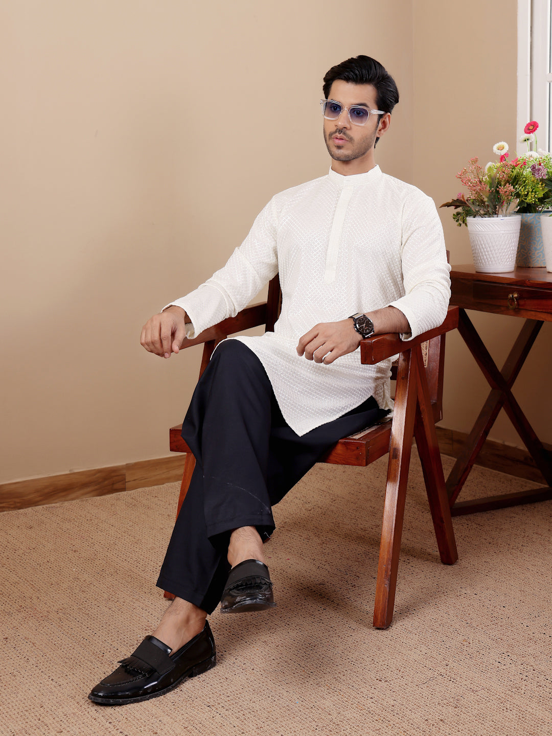 Men’s white kurta with intricate Chikankari detailing and handwoven designs on the collar and sleeves.