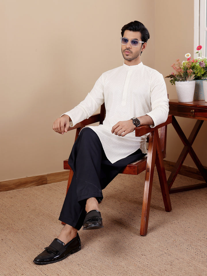 Men’s white kurta with intricate Chikankari detailing and handwoven designs on the collar and sleeves.