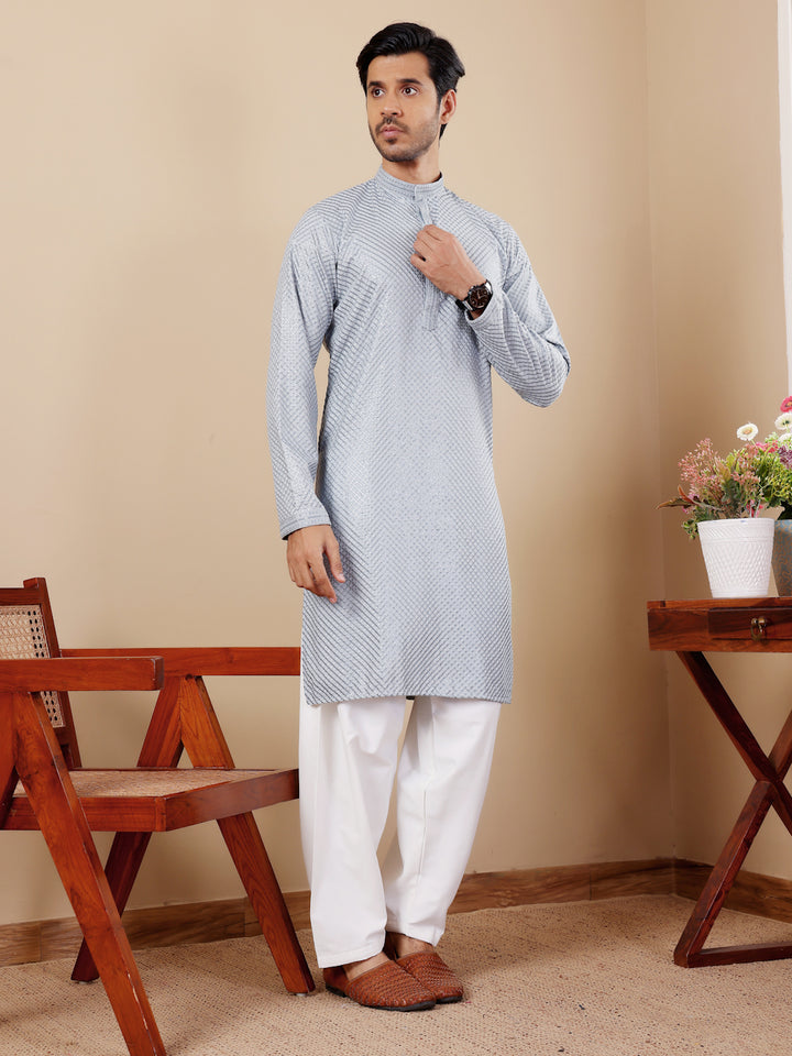 Stylish baby blue kurta set for men with traditional Chikankari embroidery and art silk bottoms.