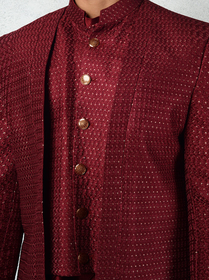 Men’s maroon Indo-Western with a silk kurta, gold buttons, and slim trousers.